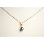 A 9ct yellow gold mounted simulated black pearl pendant on 9ct gold fine curb link chain,