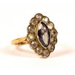 A 9ct gold dress ring set with a purple marquise cut stone surrounded by clear stones. Size N.