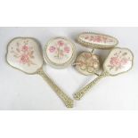 A five piece dressing table set comprising hand mirror, pair of brushes,