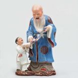 Anciano con pergamino y niño Grupo escultórico en porcelana China esmaltada y biscuit. Trabajo