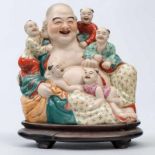 Buda con Niños Grupo escultórico en porcelana China. Siglo XX. Marca en la base. Apoya sobre peana