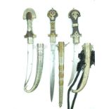 Three Moroccan Jambiya, two with slightly curved blades, one straight, white metal and brass mounted