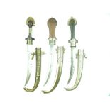 Three various Moroccan Jambiya, each with slightly curved blade, white metal and brass mounted