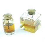 Two glass oil bottles, one square and one circular both with brass tops. (2)