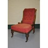 Edwardian mahogany nursing chair upholstered in buttoned red fabric on ceramic castors