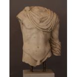 Wide marble torso of a Roman male nude with toga in ancient style; parts missing, weathered, parts