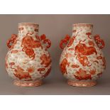 Pair of Chinese porcelain vases with red painted Fo Lions, balls, clouds and other decorations on