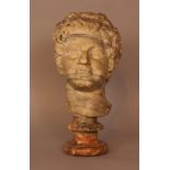Marble head of a smiling Bachus in ancient Roman manner; on later round red and grey marble base;