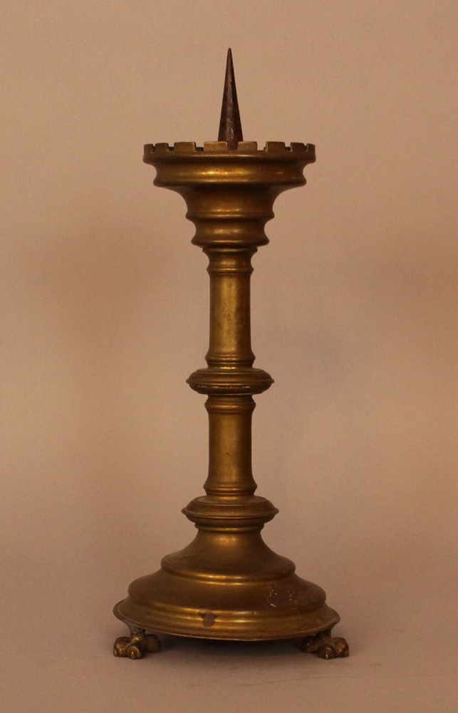 Bronze candle stick in medieval style, turned form on two lion feet with canted border and iron