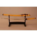 Asian sword with long grip and bowed blade, bronze hand protection and grip ending; the sword mantel