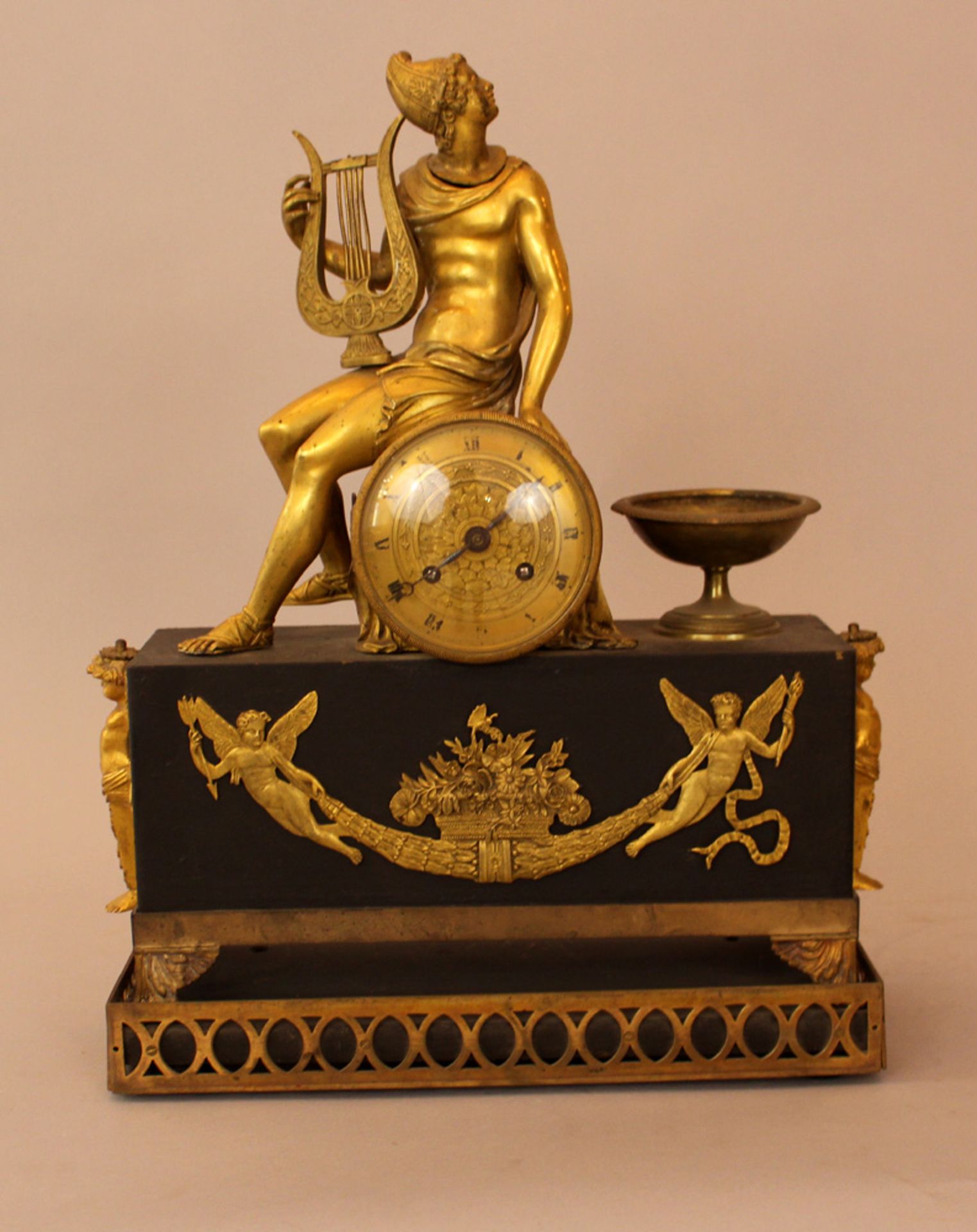 Empire clock with Hermes and the lyra on top, bronze mantel partly gilded and ebonised with round