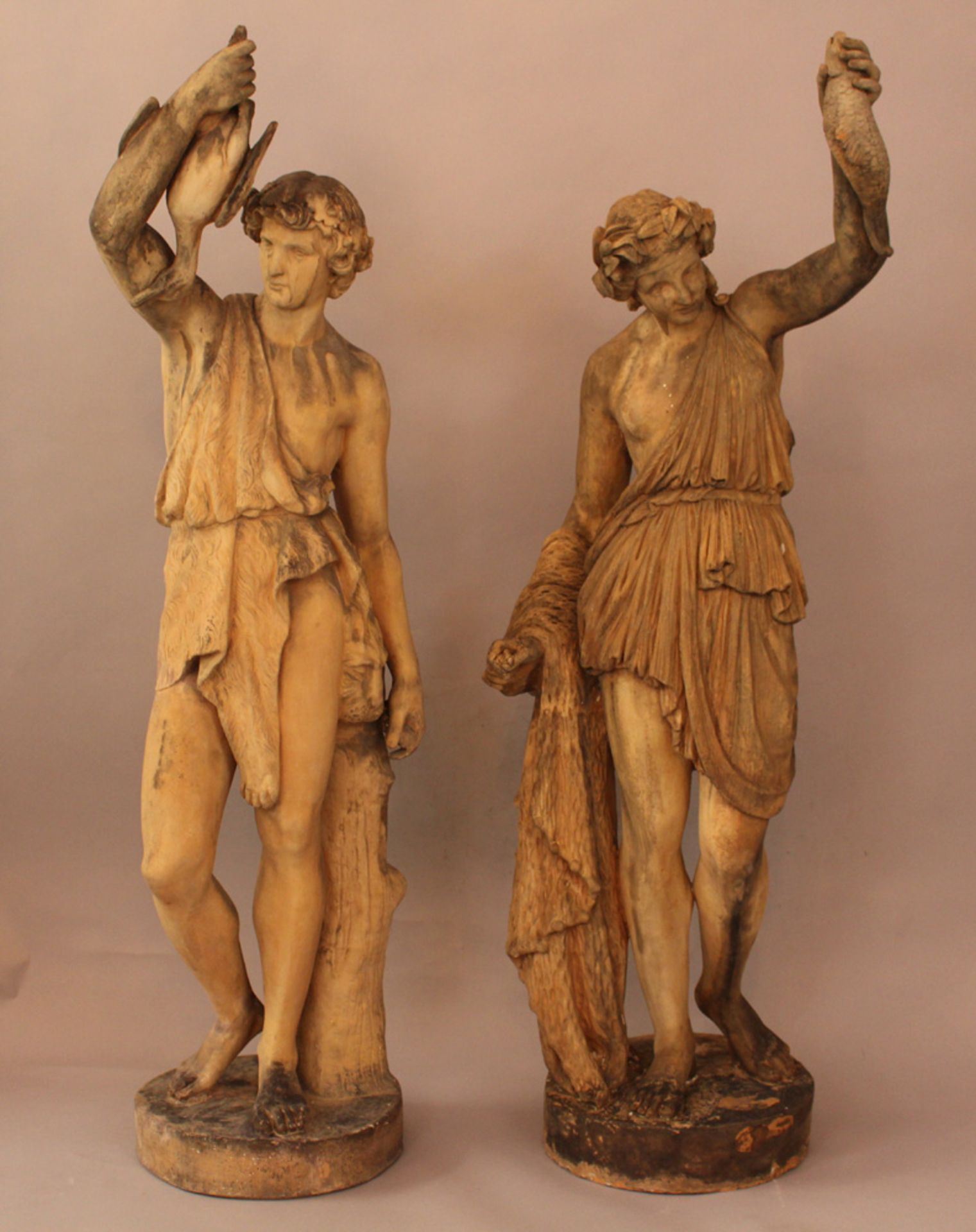 A pair of Vienna terracotta sculptures of a classical dressed girl holding a fish with toga and
