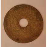 Asian stone Bi plaque in a archaic form with central hole, polished, bowed surface. diameter 30cm