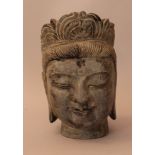 Stone head of an Asian goddness, deeply carved with crowned head, residue of former colour; signed