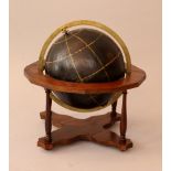 Globe in Renaissance manner with meridians, black with orange drawed lines; in bronze ring; on