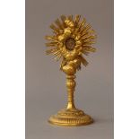 Monstrance on round foot with thin column, fluted and wood carved, turned; a reliquary on top