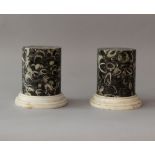 Pair of black stone collumns or bases with white fossile inclusions; round form on steppted and