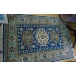 An Eastern Style Wool Rug, with blue field, multi-medallion centre and further geometric detail, set