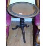 A Georgian Mahogany Occasional Table; the top with carved foliate ring band raised on a central