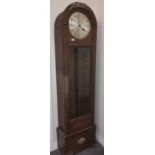 An Oak Longcase Clock, having an arched top enclosing a silvered dial with Arabic numerals and