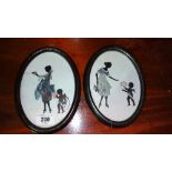 A Pair of Art Deco Silhouettes, depicting mothers and children in oval ebonised frames.
