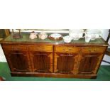A Mahogany Sideboard, 20th Century with tooled green leather top above four cupboards. 68" wide.