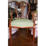 An Edwardian Solid Satinwood Elbow Chair; with a highly carved shield shape back and stuff-over