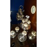 A Complete Four Cup Eggler, & Five Silver-Plated Egg Sets.
