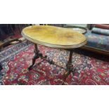 A Victorian Figured Walnut Centre Table; the oval top raised on a stretcher framework with carved