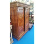 AN AGED TWO DOOR WARDROBE along with a carved pine side table and a carved walnut armchair