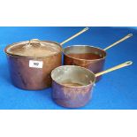 A GOOD 19TH CENTURY GRADUATED SET OF THREE COPPER SAUCEPANS with brass handles. (Sir Malcolm's