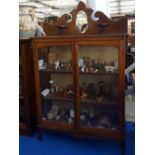 A 20TH CENTURY MAHOGANY DISPLAY CABINET with a shaped back with a bevelled mirror above the top with