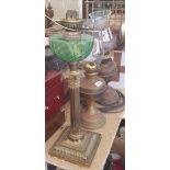 A 19TH CENTURY BRASS COLUMNED OIL LAMP with green glass bowl, along with two other oil lamps.