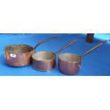 THREE 19TH CENTURY GRADUATED COPPER SAUCEPANS. (Sir Malcolm's Kitchen).