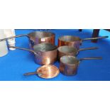 A REALLY GOOD SET OF FIVE MATCHED 19TH CENTURY COPPER SAUCEPANS, TWO WITH IRISH MARKS, with forged