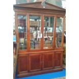 A TWO DOOR GLAZED BOOKCASE with architectural cornice.