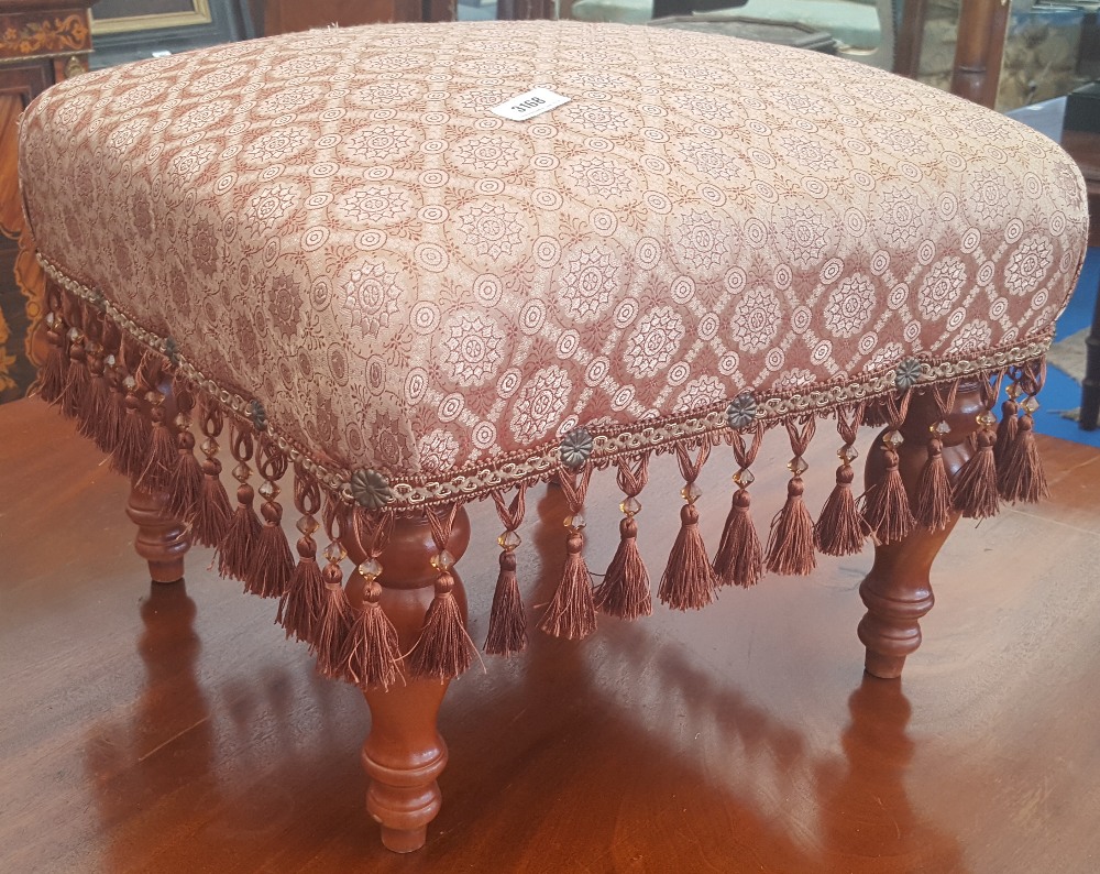 An Upholstered Footstool with Tassels.