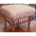 An Upholstered Footstool with Tassels.