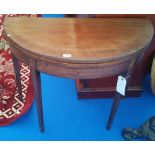 A GEORGIAN MAHOGANY FOLDOVER TEA TABLE with inlaid frieze on tapered supports.