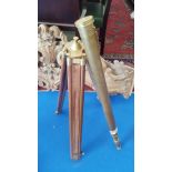 A BRASS TELESCOPE ON A TRIPOD BASE.