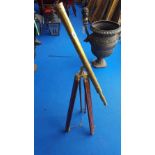 A BRASS TELESCOPE ON A TRIPOD BASE.