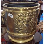 A 19TH CENTURY BRASS COAL BIN with lions head handles and rope edged top and with coat of arms to