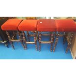 A SET OF FOUR HIGH STOOLS with upholstered seats.