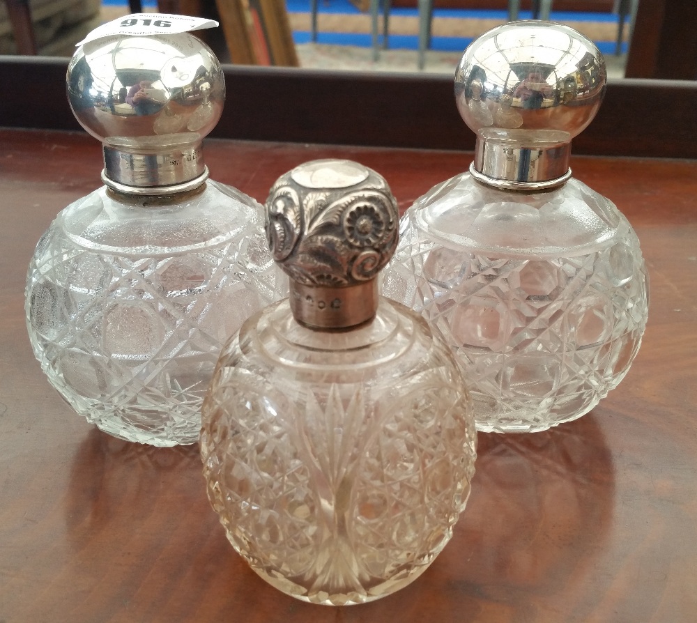 SILVER: THREE CUT GLASS AND SILVER TOPPED BOTTLES to include a pair (3).