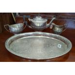 A HALF REEDED THREE-PIECE SILVER- PLATED TEA SERVICE on a rope edged oval tray.