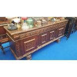 A LARGE OAK SIDEBOARD highly carved with three frieze drawers four cupboard doors on carved feet