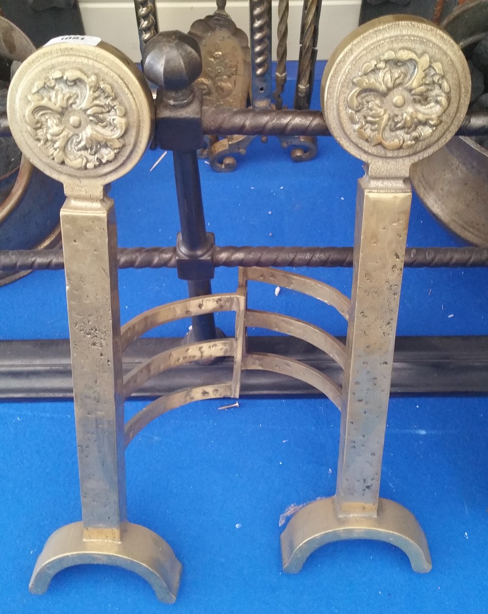 A GOOD PAIR OF BRASS FIRE SIDE ANDIRONS with decorative cut brass rosette roundels.