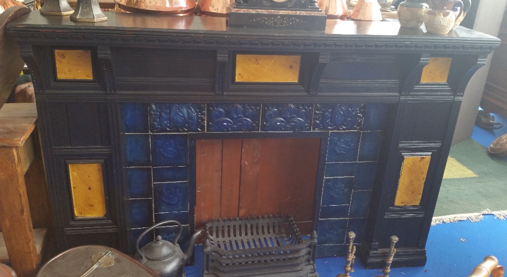 AN EBONISED FIREPLACE with a cast iron grate.
