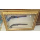 A WELL FRAMED MATCHED PAIR OF REPLICA GUNS IN A GILT FRAME.