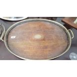 AN EDWARDIAN OAK TRAY with brass gallery top and brass handles.